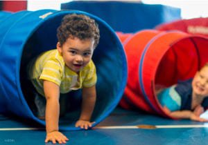 toddlers playing in play tunnels